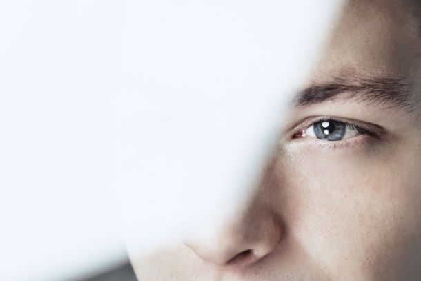 Imagen conceptual que representa el enfoque de la terapia EMDR (Desensibilización y Reprocesamiento por Movimiento Ocular). Se muestra un primer plano del rostro de una persona, enfocando especialmente su ojo azul, con el resto del encuadre desenfocado por un velo blanco que sugiere introspección o memoria difusa. Esta técnica psicoterapéutica es utilizada por Raquel Egido, psicóloga profesional, y consiste en estimular bilateralmente el cerebro (a través de movimientos oculares o táctiles) para procesar traumas, bloqueos emocionales y experiencias difíciles. La imagen transmite la mirada interna y el trabajo con la memoria implícita que caracteriza a este método.